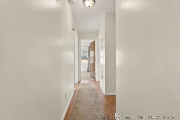 a view of a hallway with wooden floor