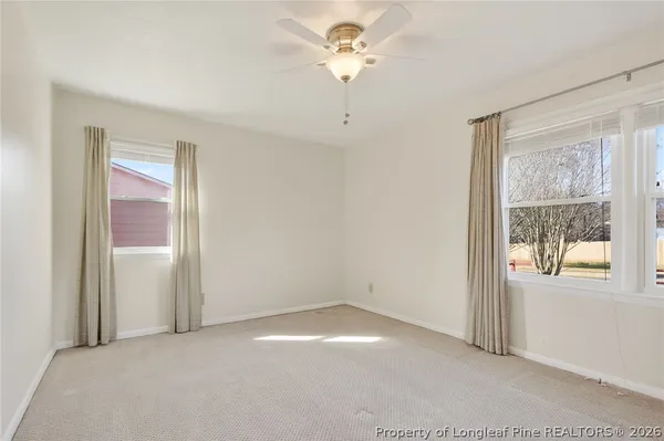 an empty room with a window and a fan