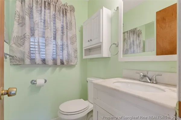 a bathroom with a granite countertop sink a toilet and a mirror