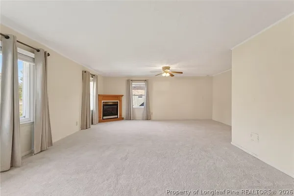 a view of empty room with a fireplace and fan