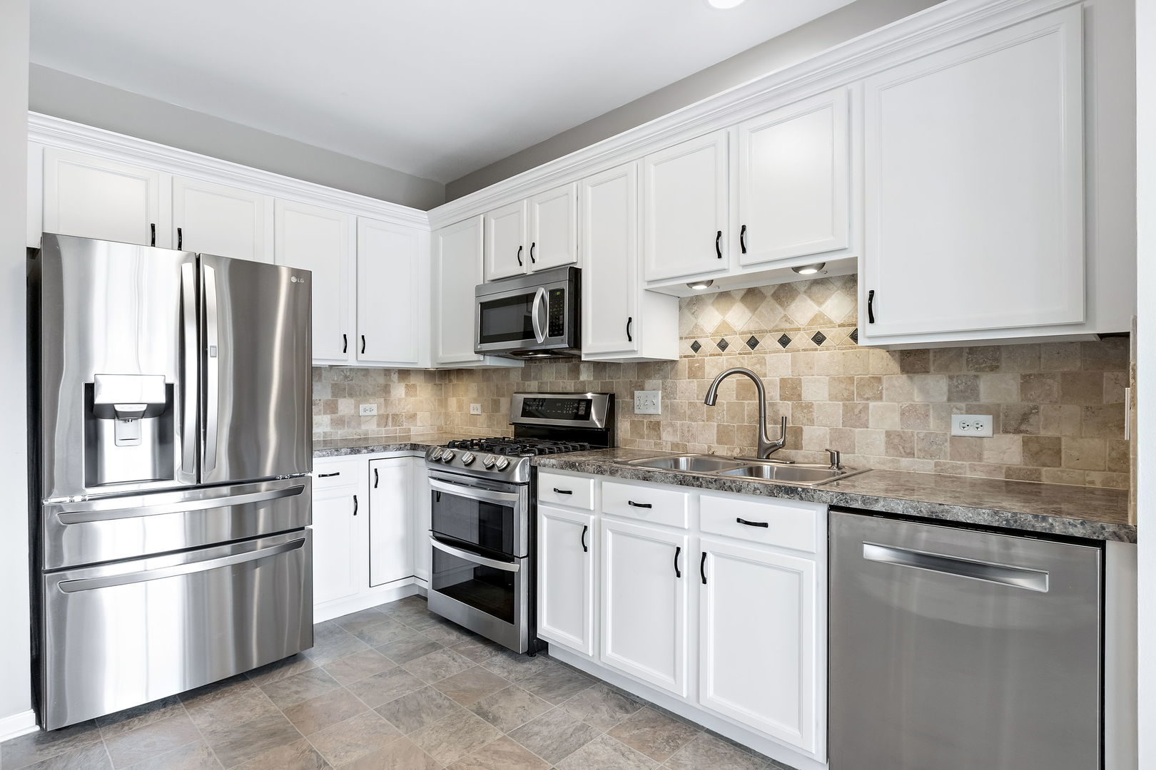 954 Oak Ridge Boulevard Elgin, IL 60120 - Photo 7 of 17 a kitchen with stainless steel appliances granite countertop a refrigerator sink and white cabinets