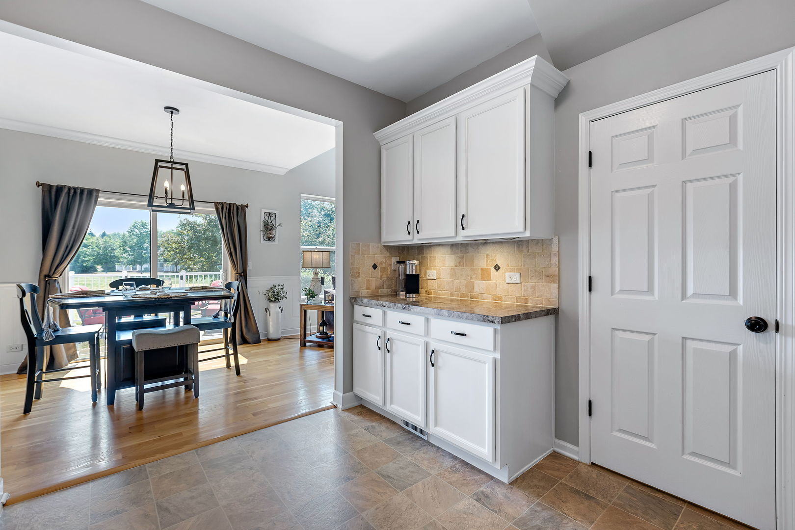 954 Oak Ridge Boulevard Elgin, IL 60120 - Photo 9 of 17 a kitchen with granite countertop a stove top oven a sink a dining table and chairs with wooden floor