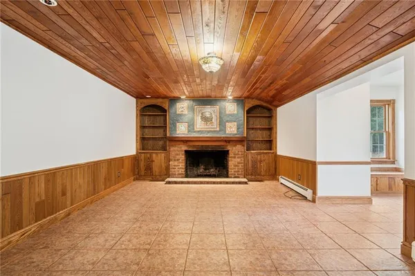 a view of an empty room with a fireplace and a window