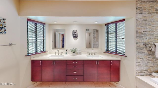 a bathroom with a bathtub shower sink and mirror