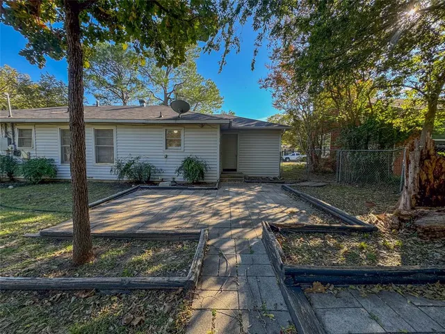 a view of a house with a yard fire pit and a large tree