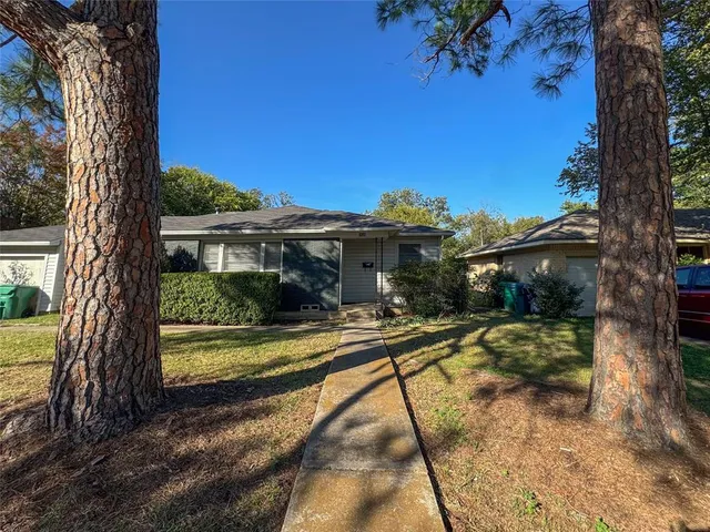 a view of a house with backyard and a tree