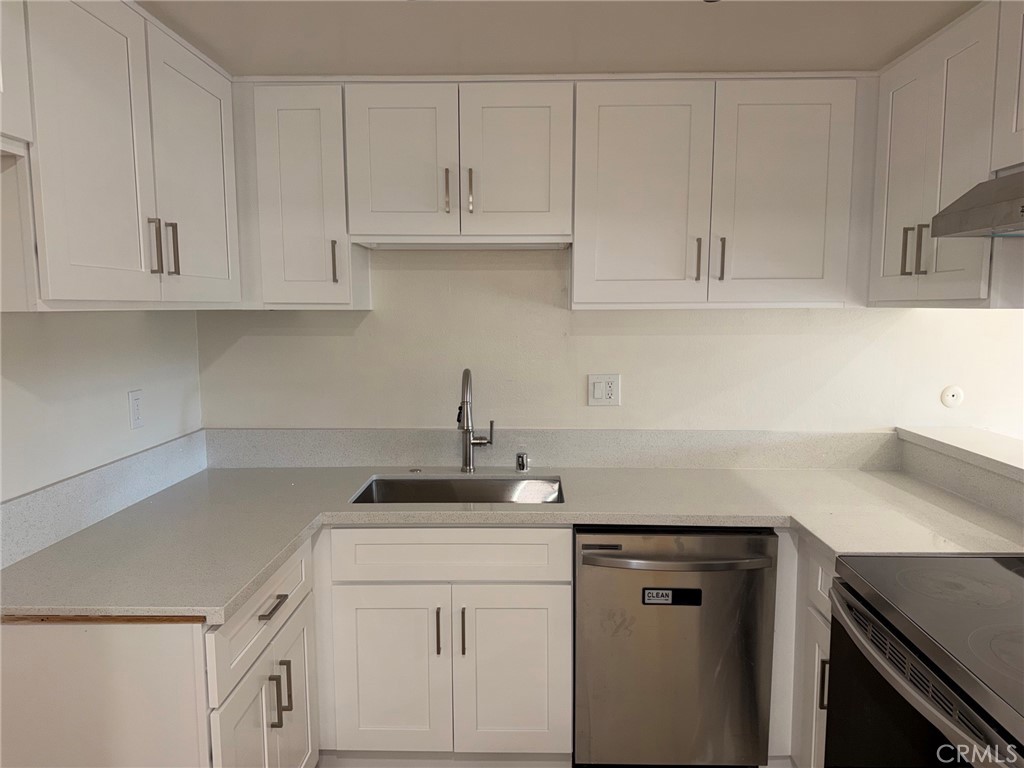 3054 Associated, Unit 26 Fullerton, CA 92835 - Photo 2 of 27 a kitchen with white cabinets and a sink