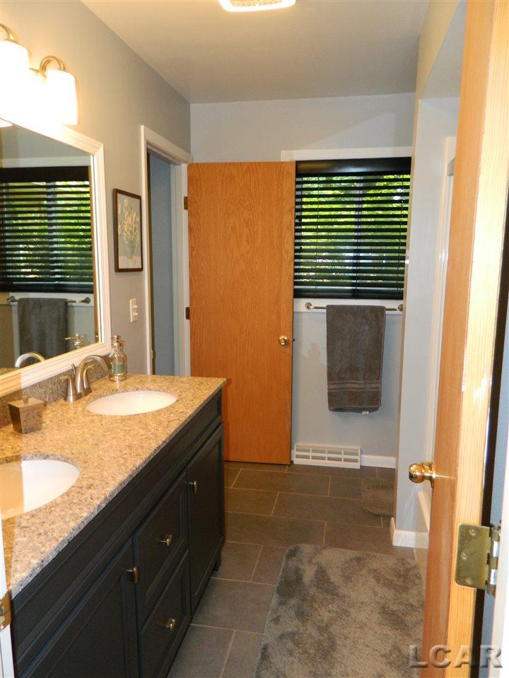 2689 West Russell Road Tecumseh, MI 49286 - Photo 12 of 28 The tastefully remodeled bathroom offers double vanity and sinks, newer floors, shower, etc.