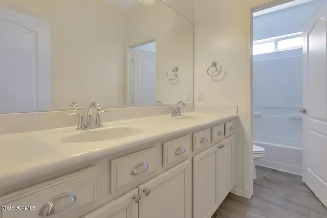 a bathroom with double sink and a large mirror