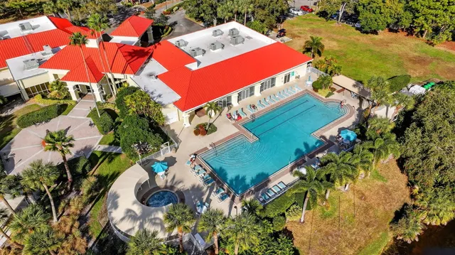 an aerial view of a swimming pool with a yard and lake view