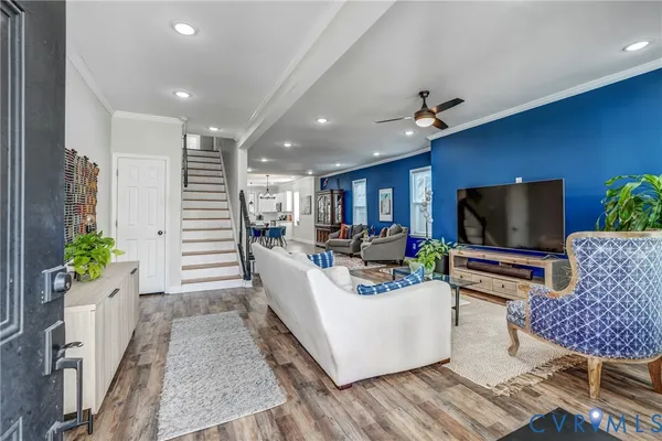 a view of a dining room and livingroom with furniture wooden floor a chandelier