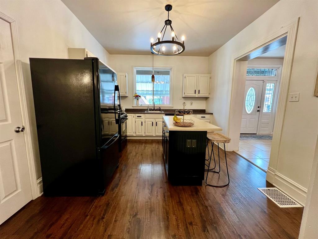 237 Lelia Street Pittsburgh, PA 15211 - Photo 11 of 46 a kitchen with stainless steel appliances granite countertop wooden floors a stove and white cabinets