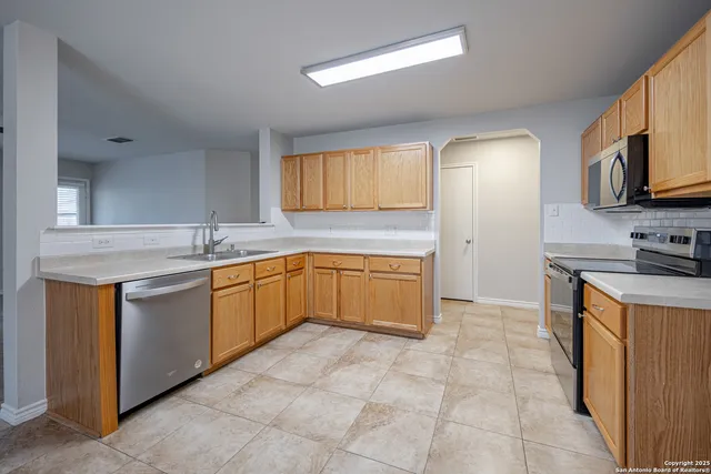 a kitchen with stainless steel appliances granite countertop a sink counter space cabinets and a window