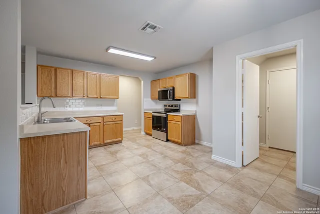 a kitchen with a sink a counter top space and cabinets