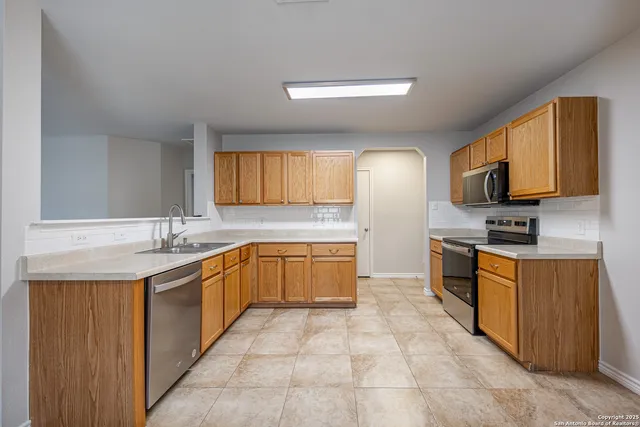 a large kitchen with stainless steel appliances lots of counter space and a sink