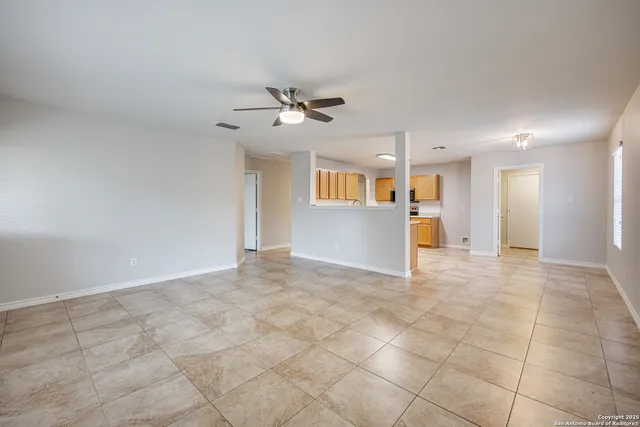 a view of a livingroom with a chandelier fan and windows