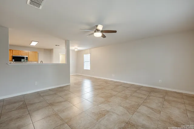 an empty room with a empty space and a kitchen view