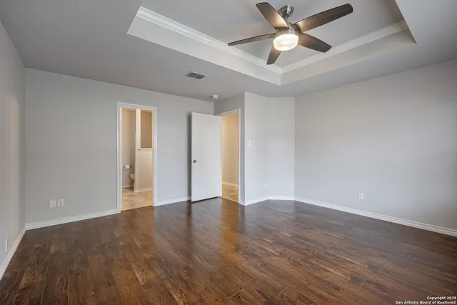a view of an empty room with window and wooden floor