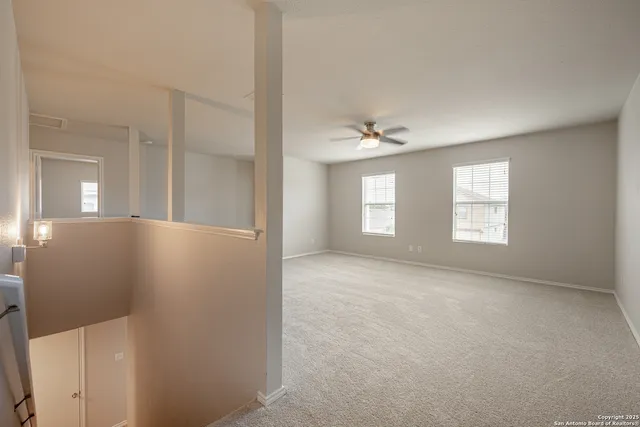 an empty room with windows and mirror