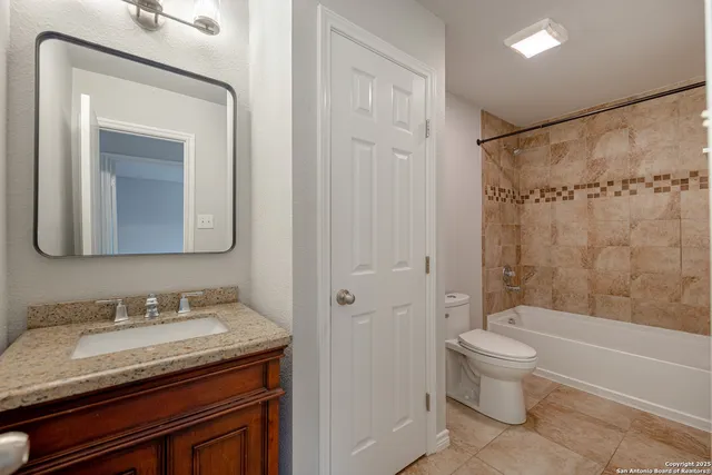 a bathroom with a granite countertop sink toilet and shower