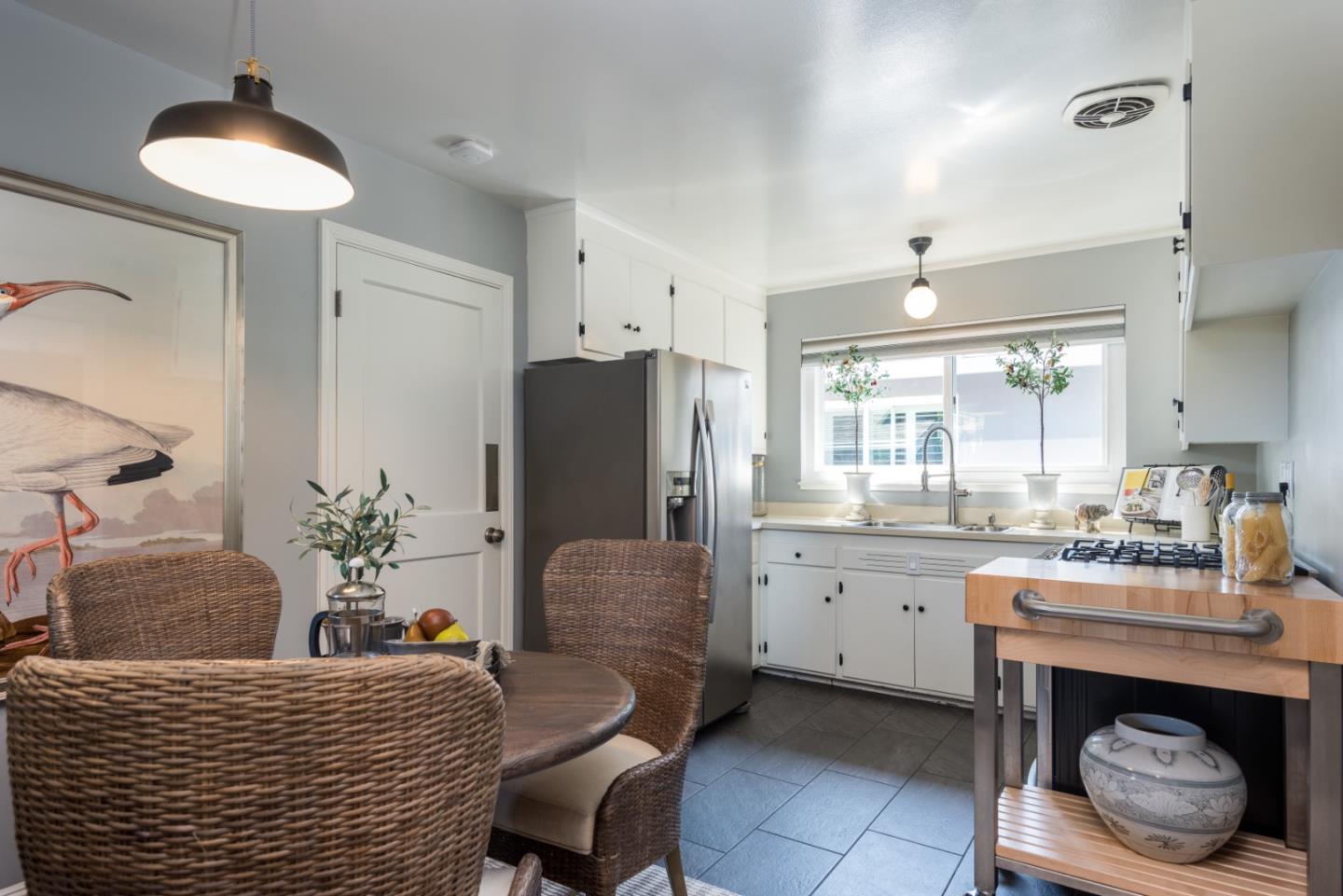115 Chukker Court San Mateo, CA 94403 - Photo 7 of 23 a kitchen with sink refrigerator dining table and chairs