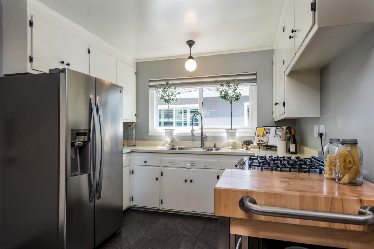 115 Chukker Court San Mateo, CA 94403 - Photo 8 of 23 a kitchen with kitchen island white cabinets and stainless steel appliances