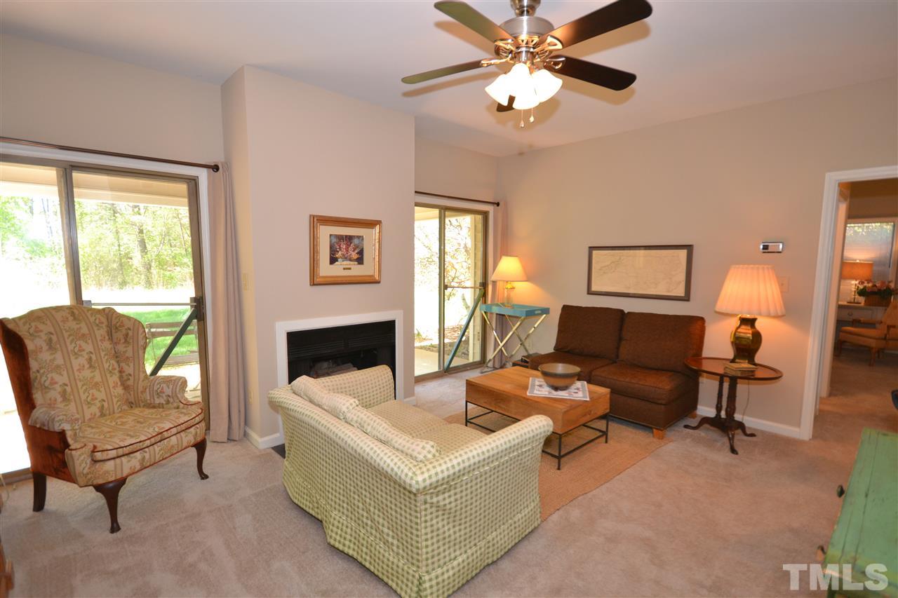 6151 Summer Pointe Place, Unit 103 Raleigh, NC 27606 - Photo 3 of 12 Wood-burning fireplace and large book shelves make this space feel cozy.