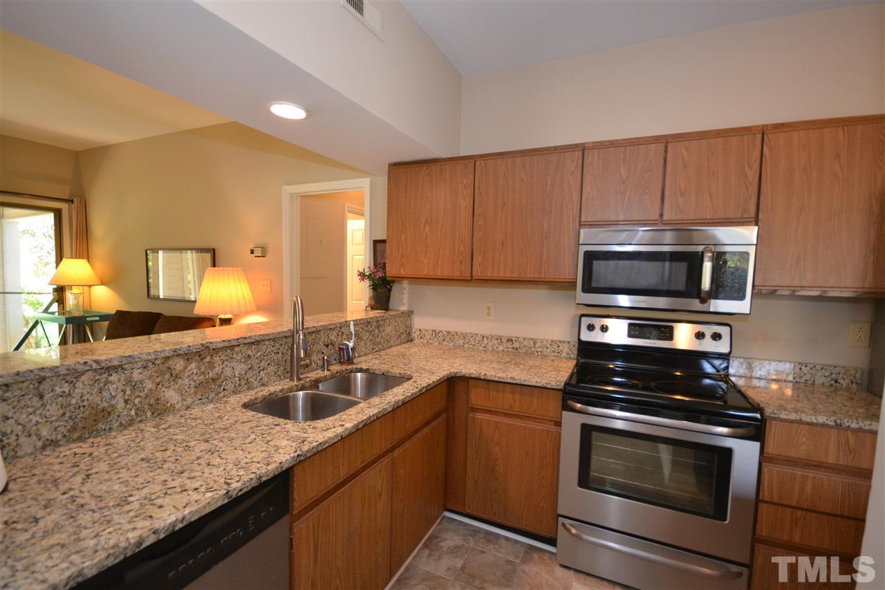 6151 Summer Pointe Place, Unit 103 Raleigh, NC 27606 - Photo 5 of 12 Kitchen boasts beautiful granite countertops. Lots of cabinet space and large pantry with shelving.
