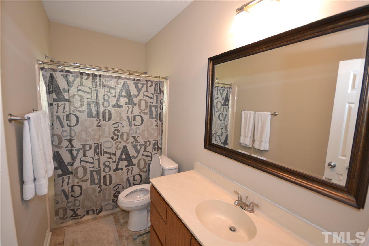 6151 Summer Pointe Place, Unit 103 Raleigh, NC 27606 - Photo 8 of 12 Bathroom features cultured marble countertops and garden tub/shower with tile walls.