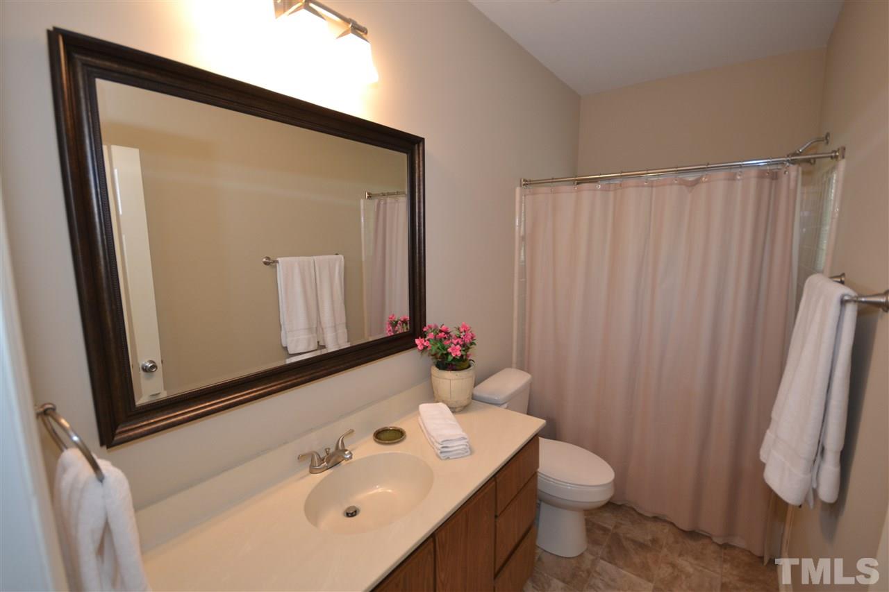 6151 Summer Pointe Place, Unit 103 Raleigh, NC 27606 - Photo 10 of 12 Bathroom features cultured marble countertops and garden tub/shower with tile walls.