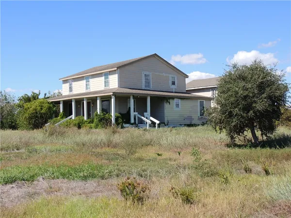 a view of a yard in front of a house with large trees
