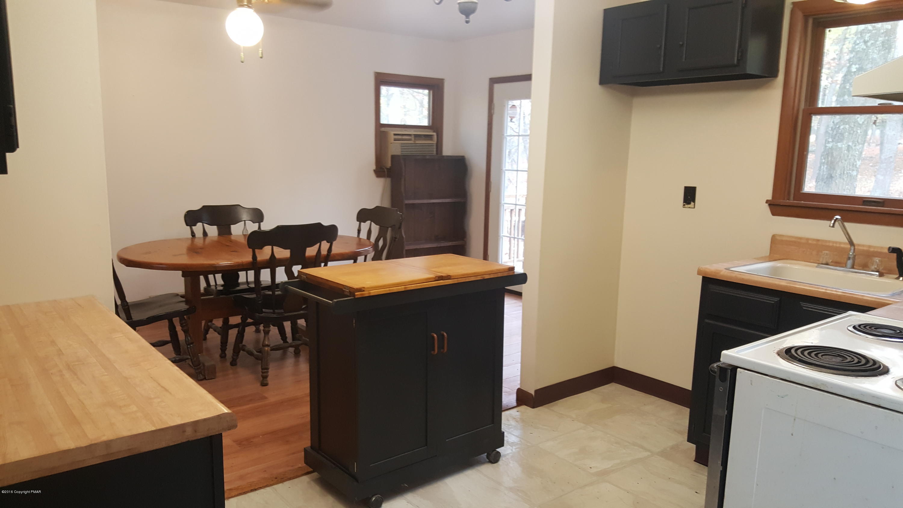 114 Weasel Road Dingmans Ferry, PA 18328 - Photo 17 of 51 a kitchen with a table chairs and a stove