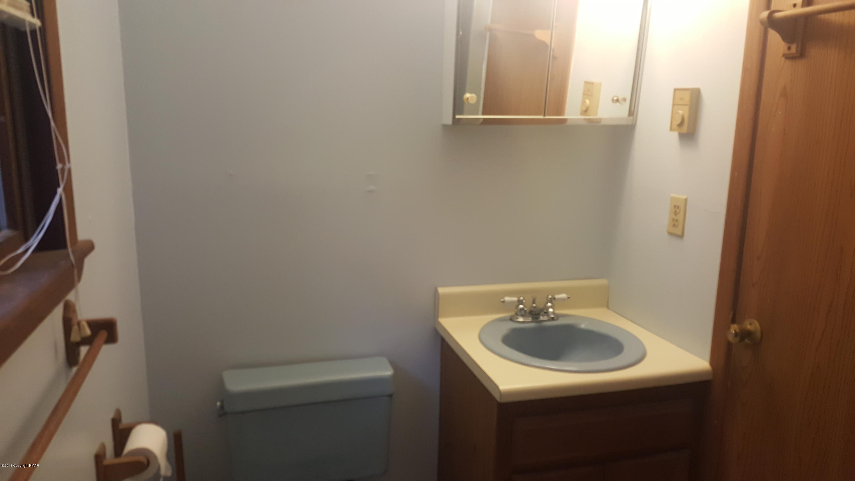 114 Weasel Road Dingmans Ferry, PA 18328 - Photo 25 of 51 a bathroom with a sink a toilet and a mirror