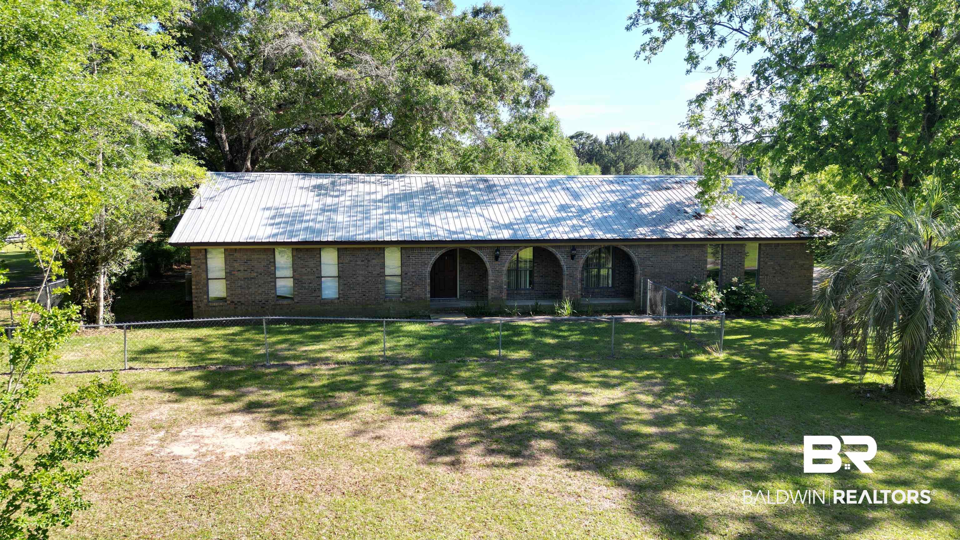 33370 Highway 98 Lillian, AL 36549 - Photo 8 of 58 Brick exterior featuring a metal roof and an arched covered entry