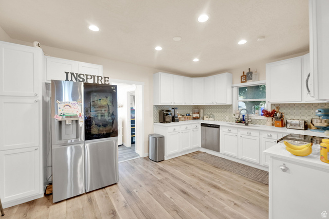501 Canyon Road Ogden, UT 84404 - Photo 22 of 30 Bright kitchen featuring white cabinetry, wood-finish flooring, recessed lighting, and a patterned tile backsplash