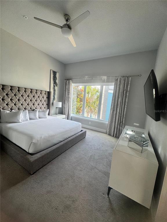 7770 Sandy Ridge Drive, Unit 210 Reunion, FL 34747 - Photo 36 of 42 a bedroom with a bed a flat screen tv and window