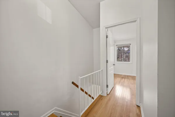 a view of a hallway with wooden floor and entryway