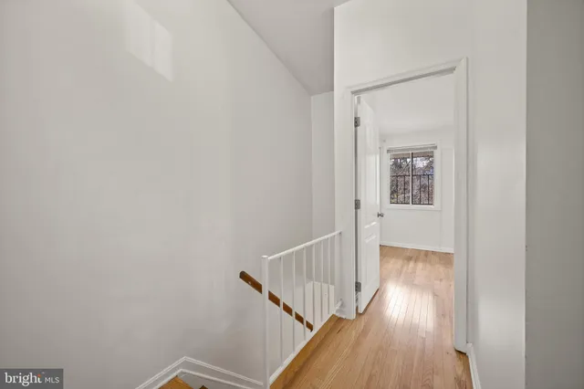 a view of a hallway with wooden floor and entryway
