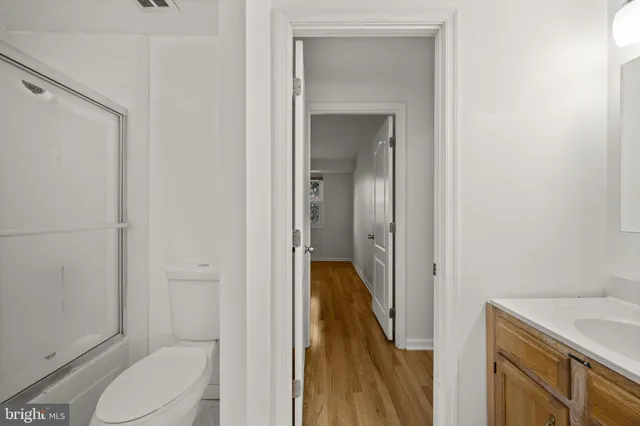a bathroom with a granite countertop sink vanity mirror and toilet
