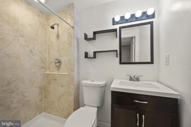 a bathroom with a toilet sink vanity and mirror