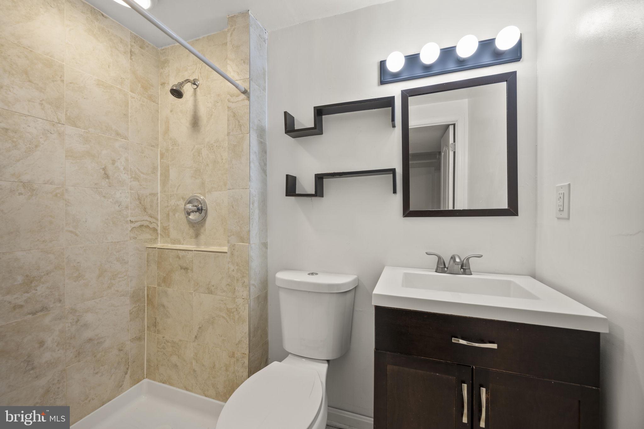 5451 Endicott Lane Columbia, MD 21044 - Photo 24 of 28 a bathroom with a toilet sink vanity and mirror