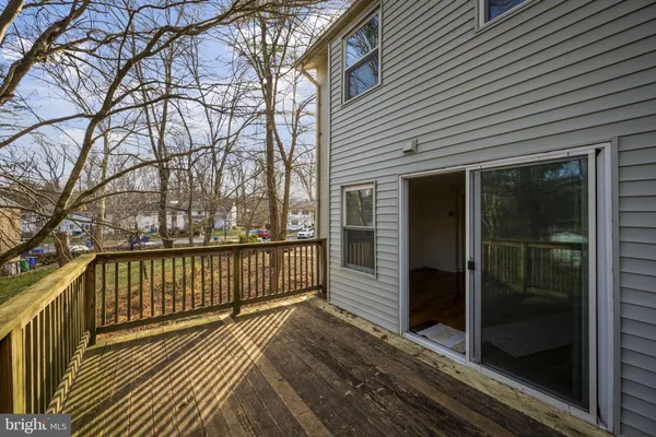 a view of a balcony with wooden floor and fence and a window