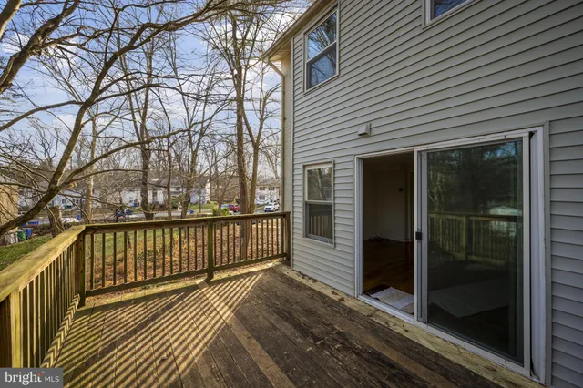 a view of a balcony with wooden floor and fence and a window