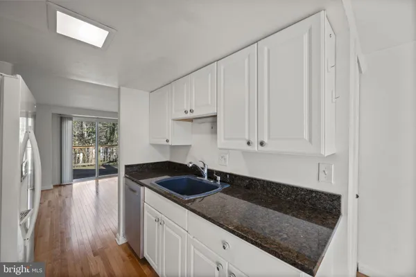 a kitchen with granite countertop a sink and cabinets