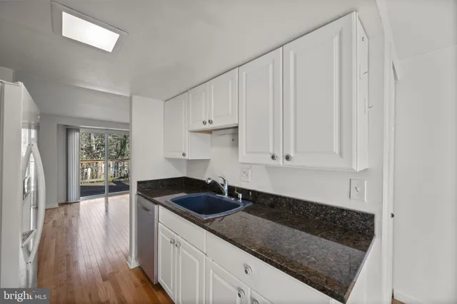 a kitchen with granite countertop a sink and cabinets