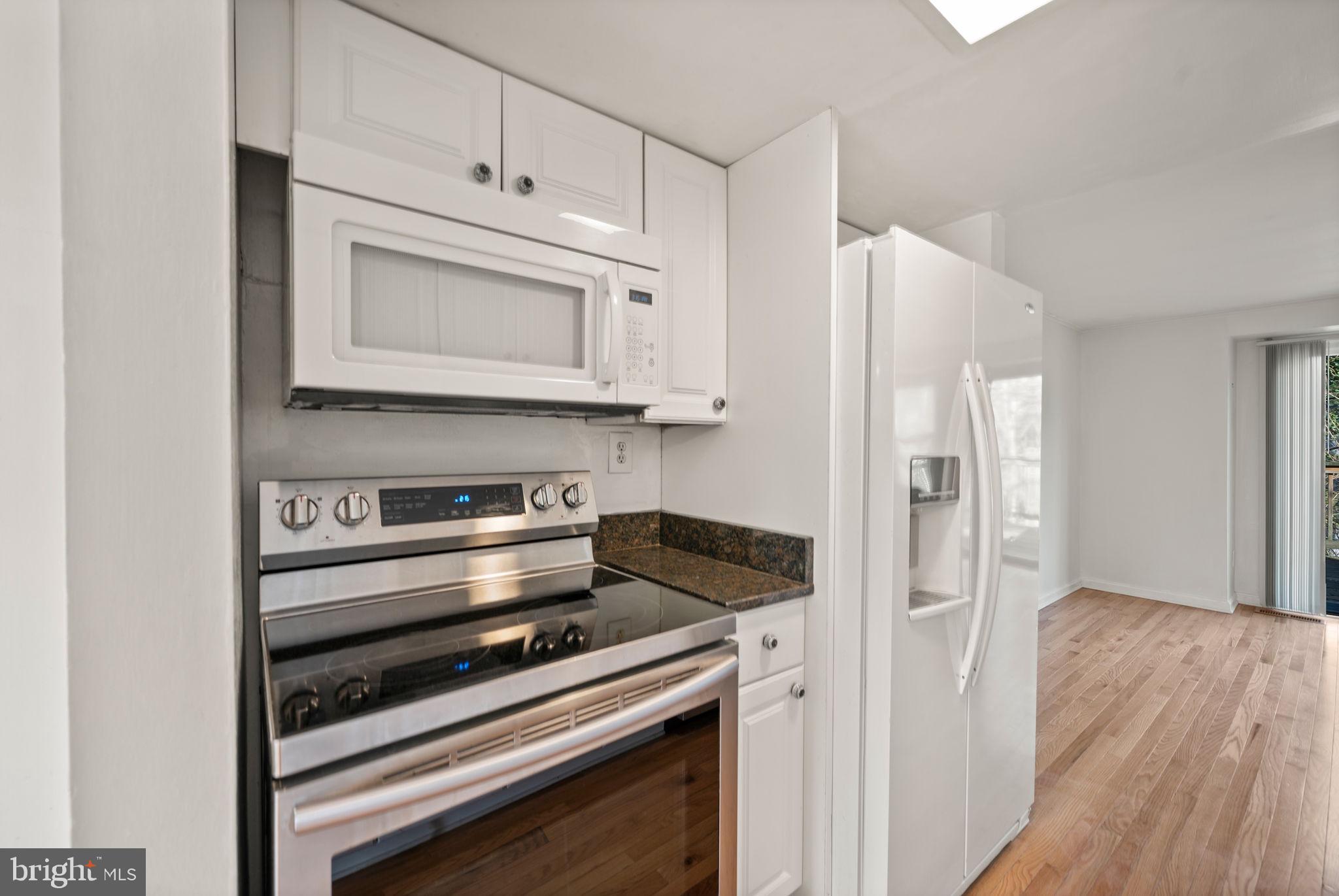 5451 Endicott Lane Columbia, MD 21044 - Photo 5 of 28 a kitchen with granite countertop cabinets stainless steel appliances and wooden floor