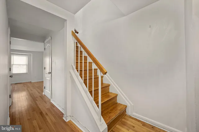 a view of a hallway with wooden floor and staircase