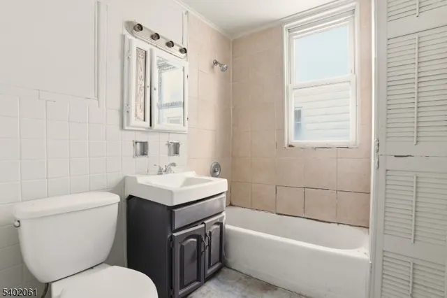a kitchen with a wooden floor and white cabinets