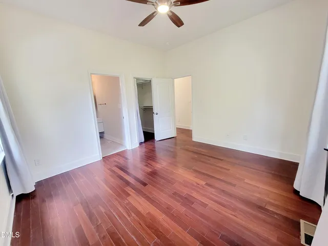 a view of empty room with wooden floor