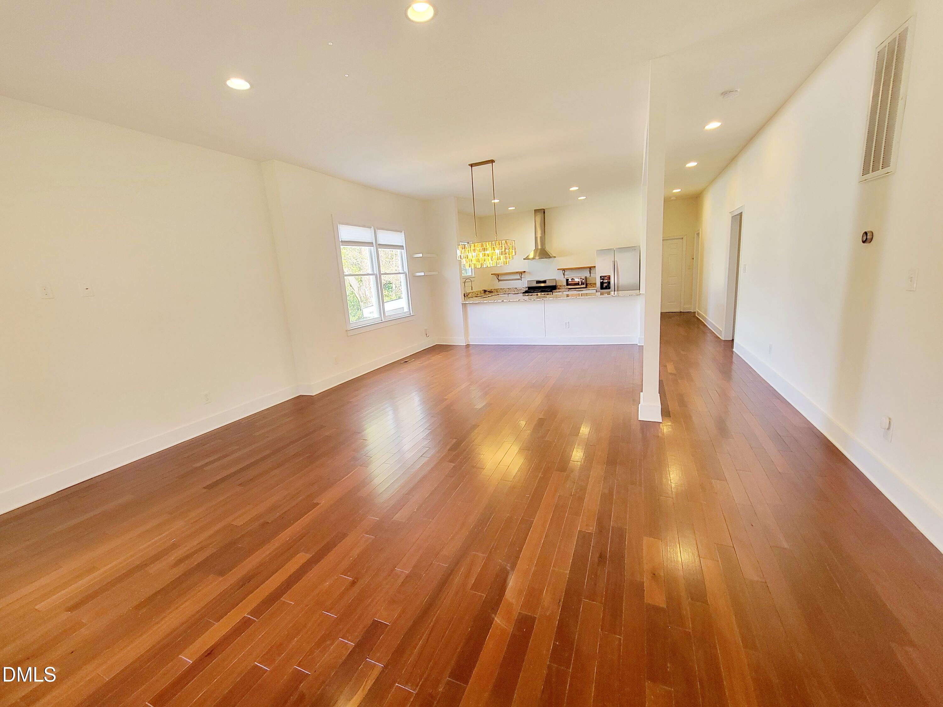 707 South East Street Raleigh, NC 27601 - Photo 3 of 46 a view of an empty room and kitchen with wooden floor